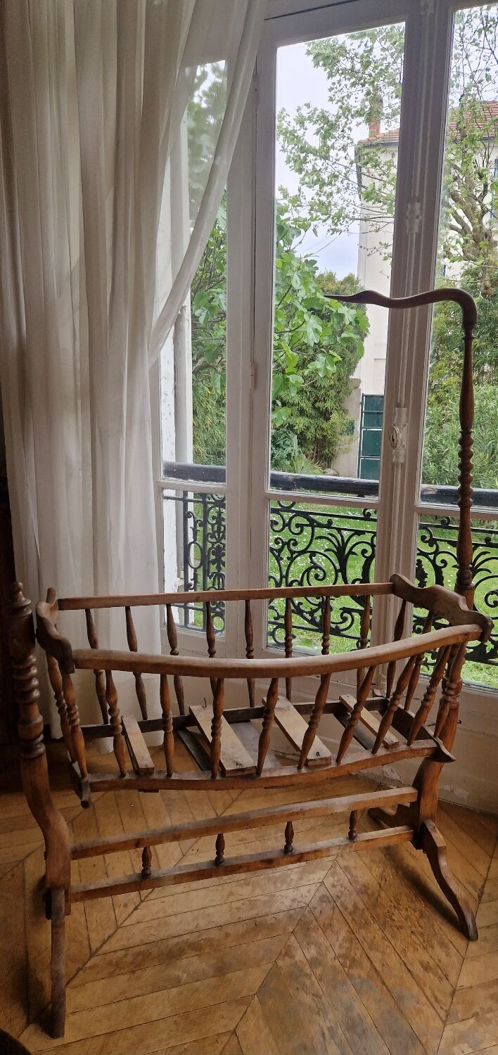 Wooden cradle in walnut with a sign collar at the top.