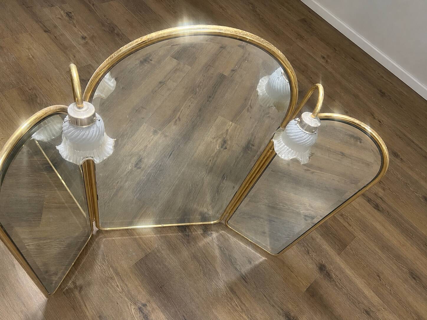 Vintage triptych mirror in brass with wall lights.