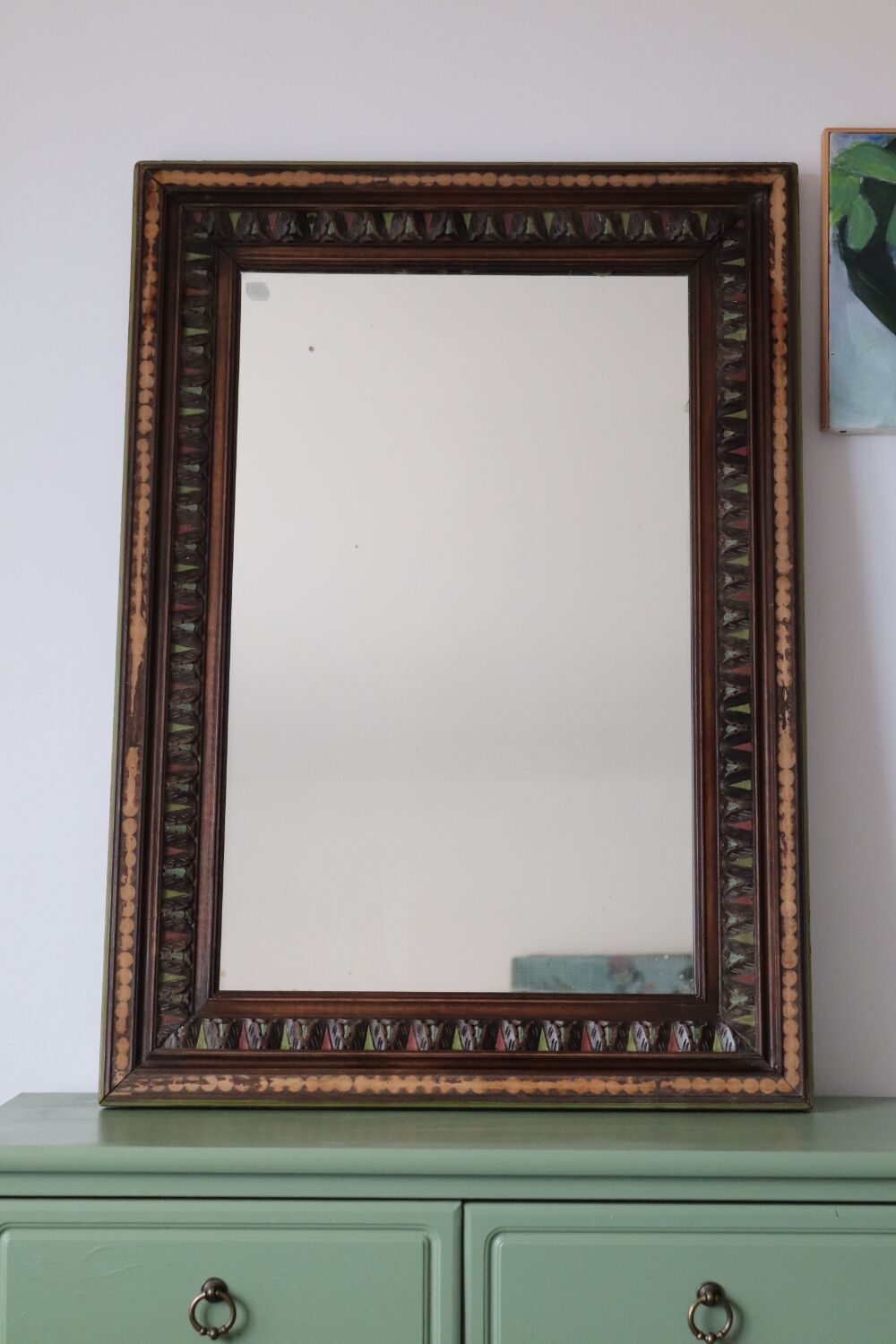 Antique mirror with a carved and painted wooden frame