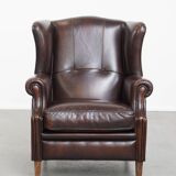 Comfortable wingback chair in English style made of cowhide leather