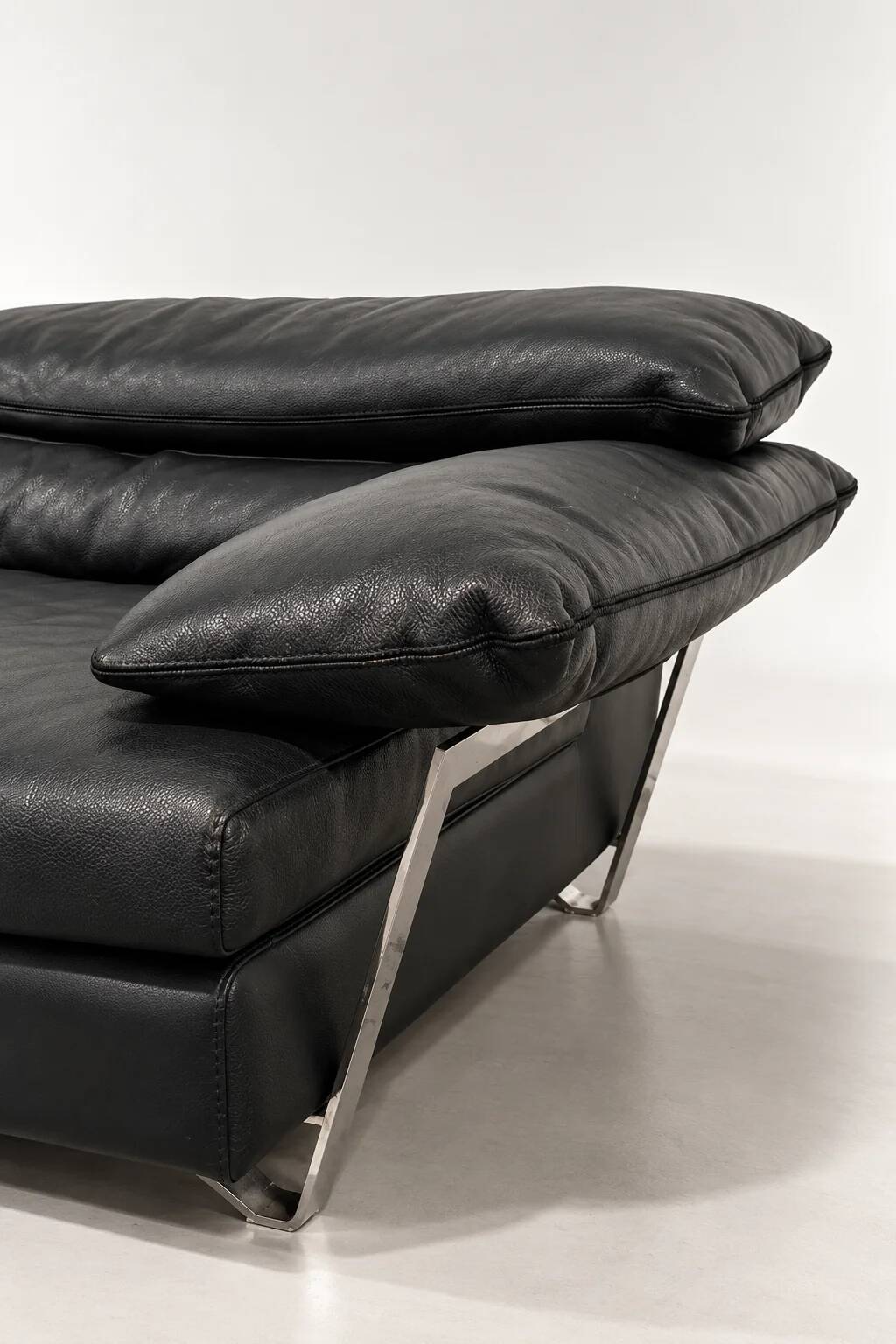 Two-seater black leather sofa from Roche Bobois with a chrome frame.