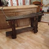 Small, very old, brutalist workbench equipped with a period workshop lamp
