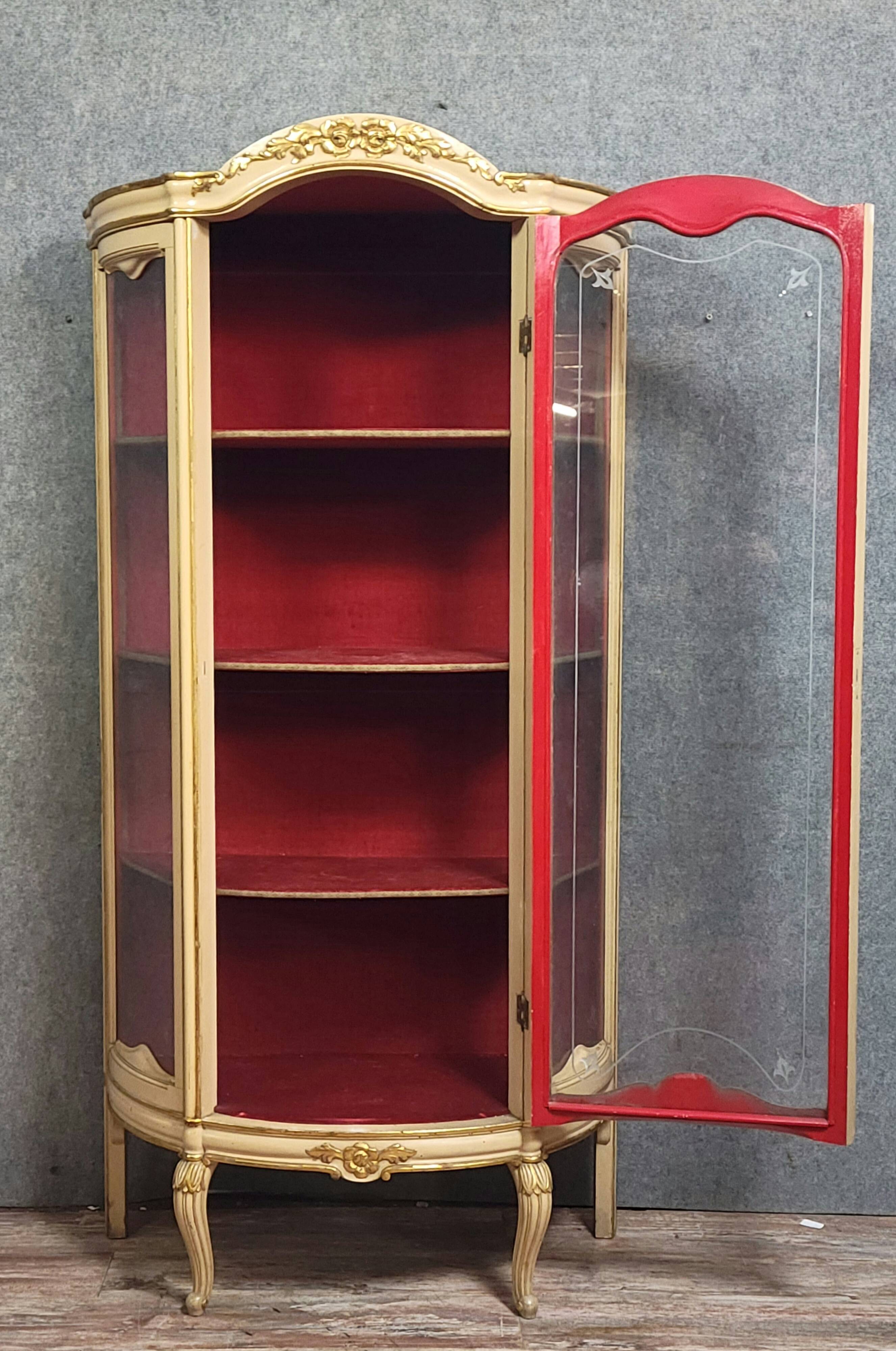 Curved display cabinet in Louis XV style, in cream lacquered wood enhanced with gilding.