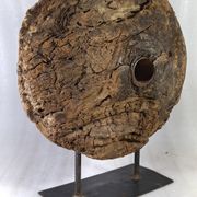 Old wooden pulley wheel on foot
