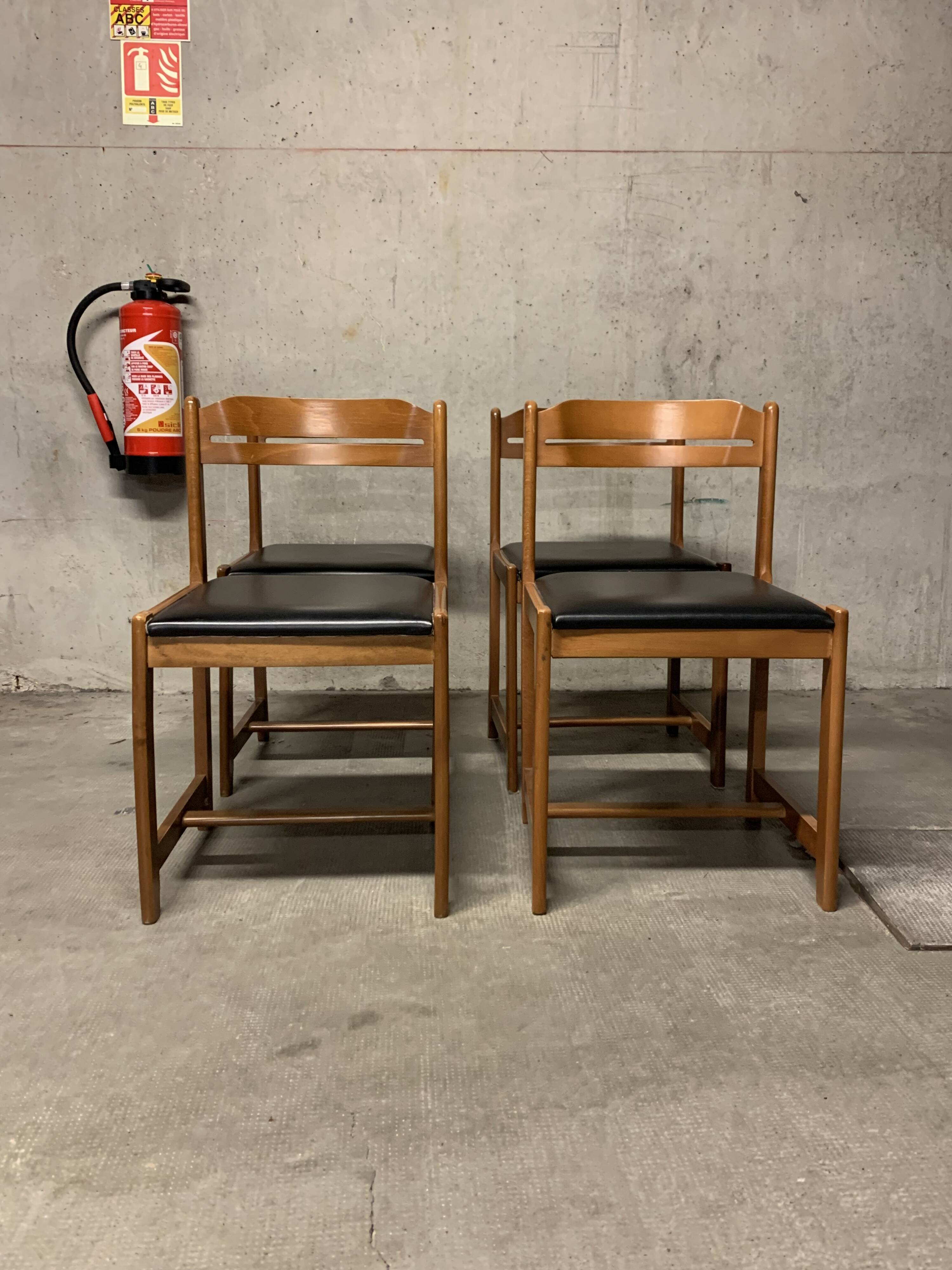 Set of four vintage chairs upholstered in retro design faux leather.