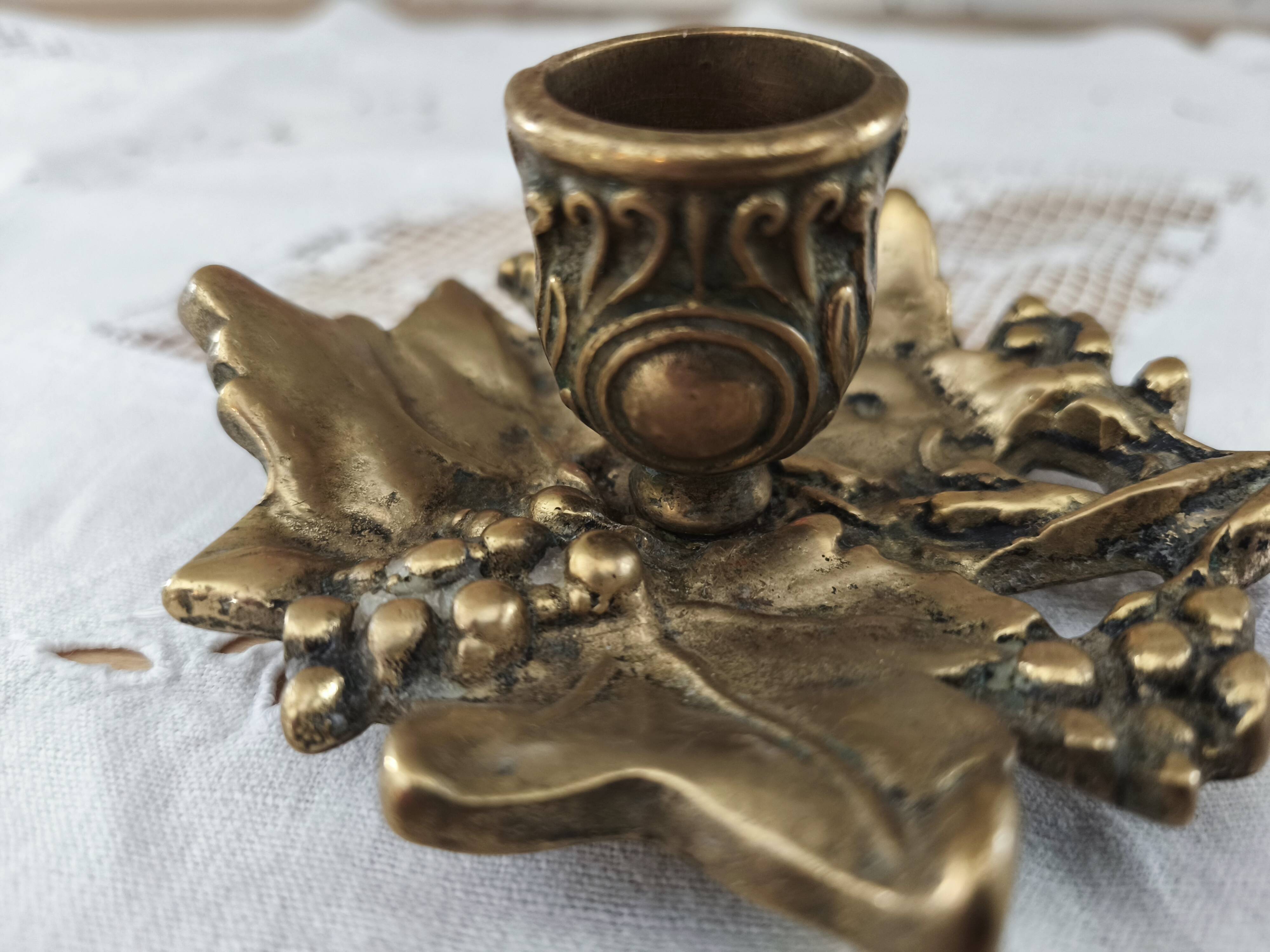 Hand-held candle holder called "cellar rat" in brass with vine leaf decoration