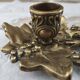 Hand-held candle holder called "cellar rat" in brass with vine leaf decoration