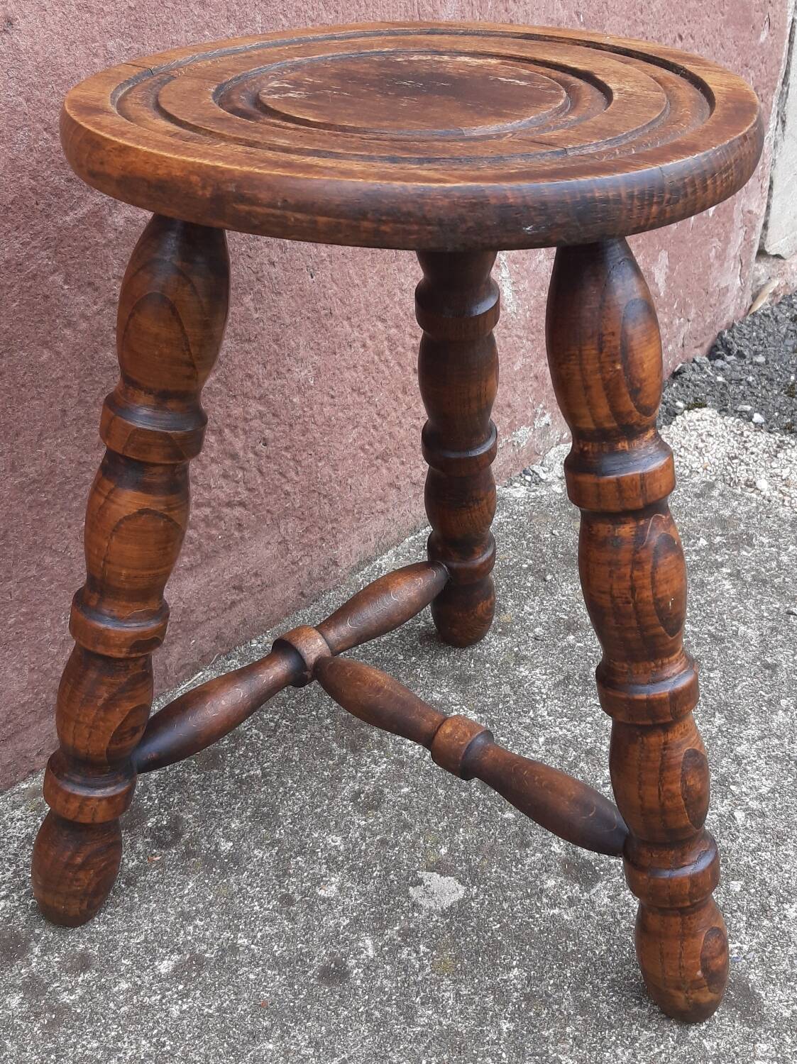 Low wooden tripod stool.