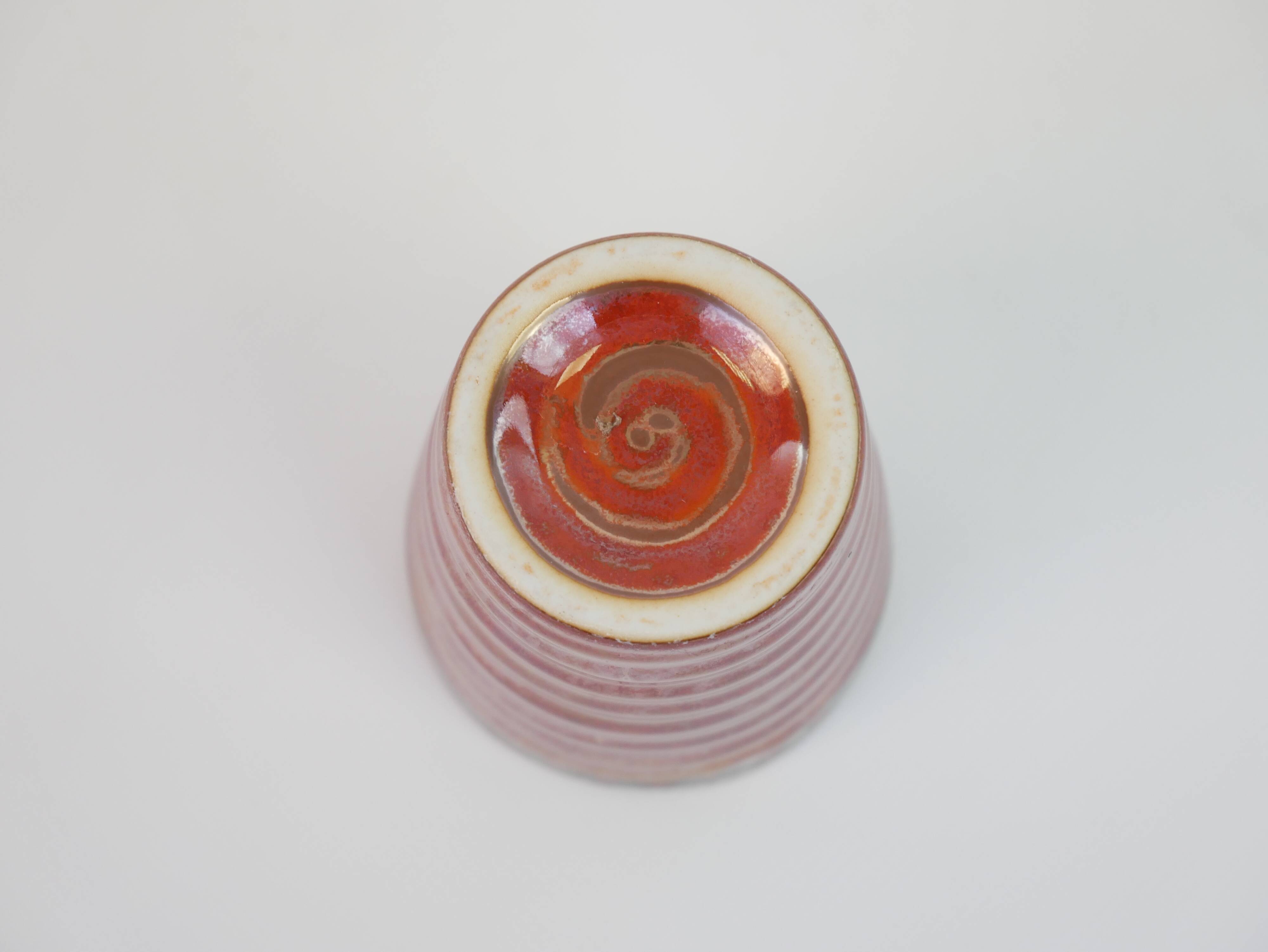 Small orange glazed ceramic cup