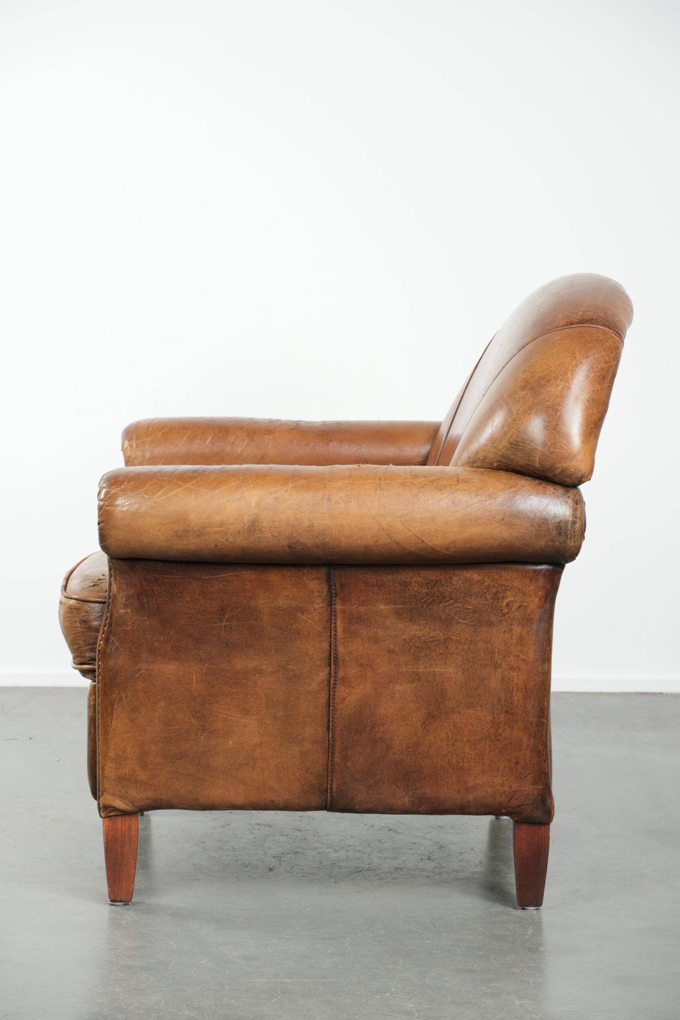 Sheepskin armchair with a beautiful vintage look and decorative nail finish