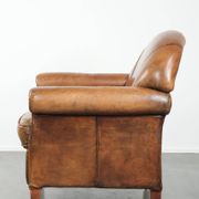 Sheepskin armchair with a beautiful vintage look and decorative nail finish