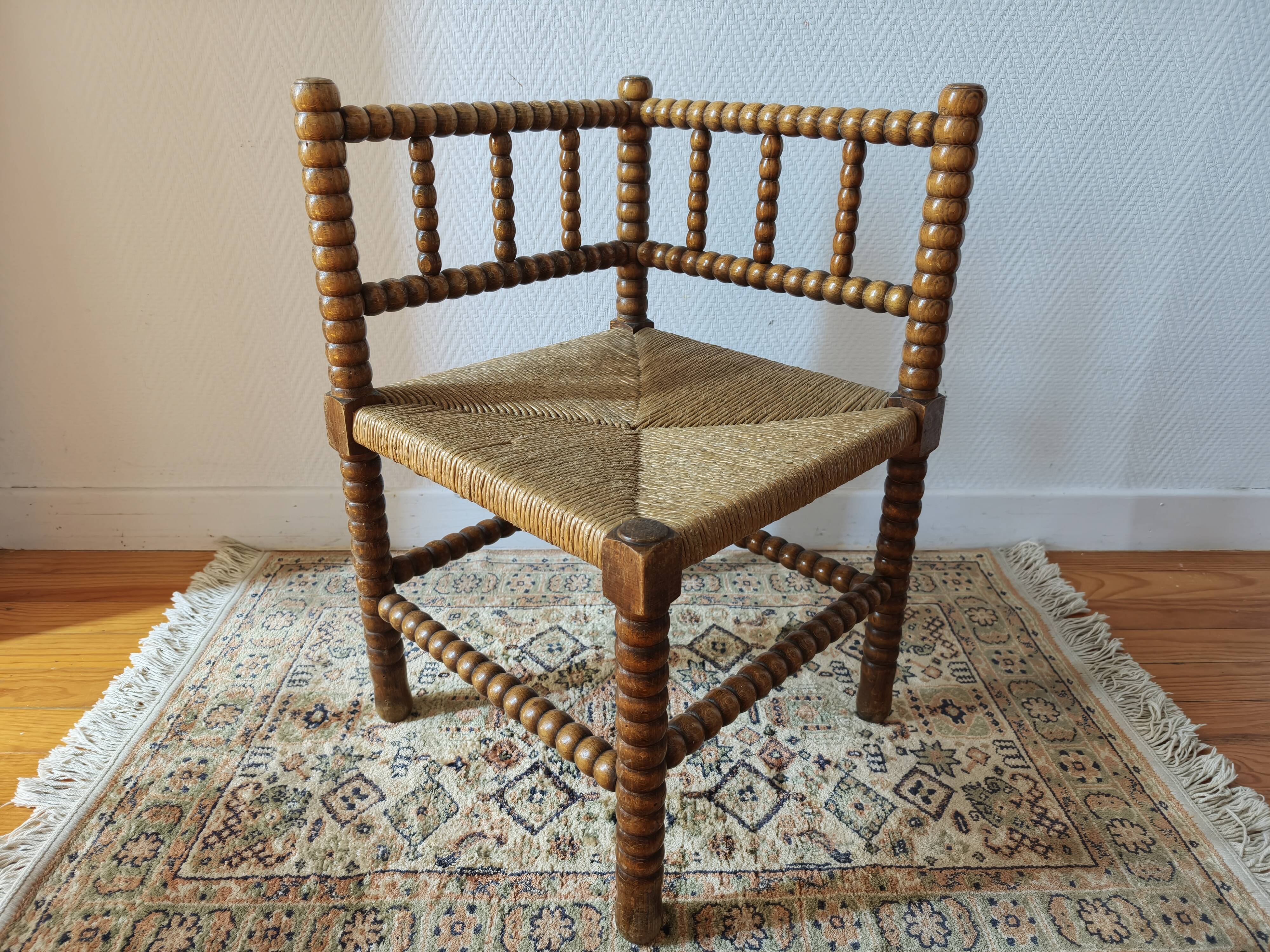 Antique corner chair by the fire with turned wood and straw seat.