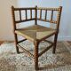 Antique corner chair by the fire with turned wood and straw seat.