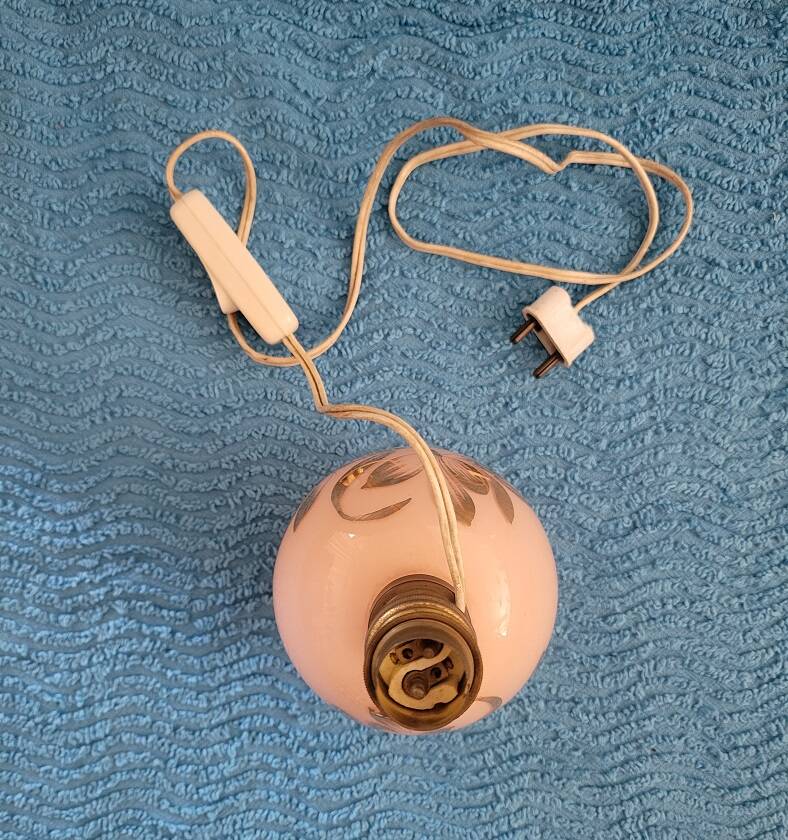 Antique lamp base with globe from the early 20th century.