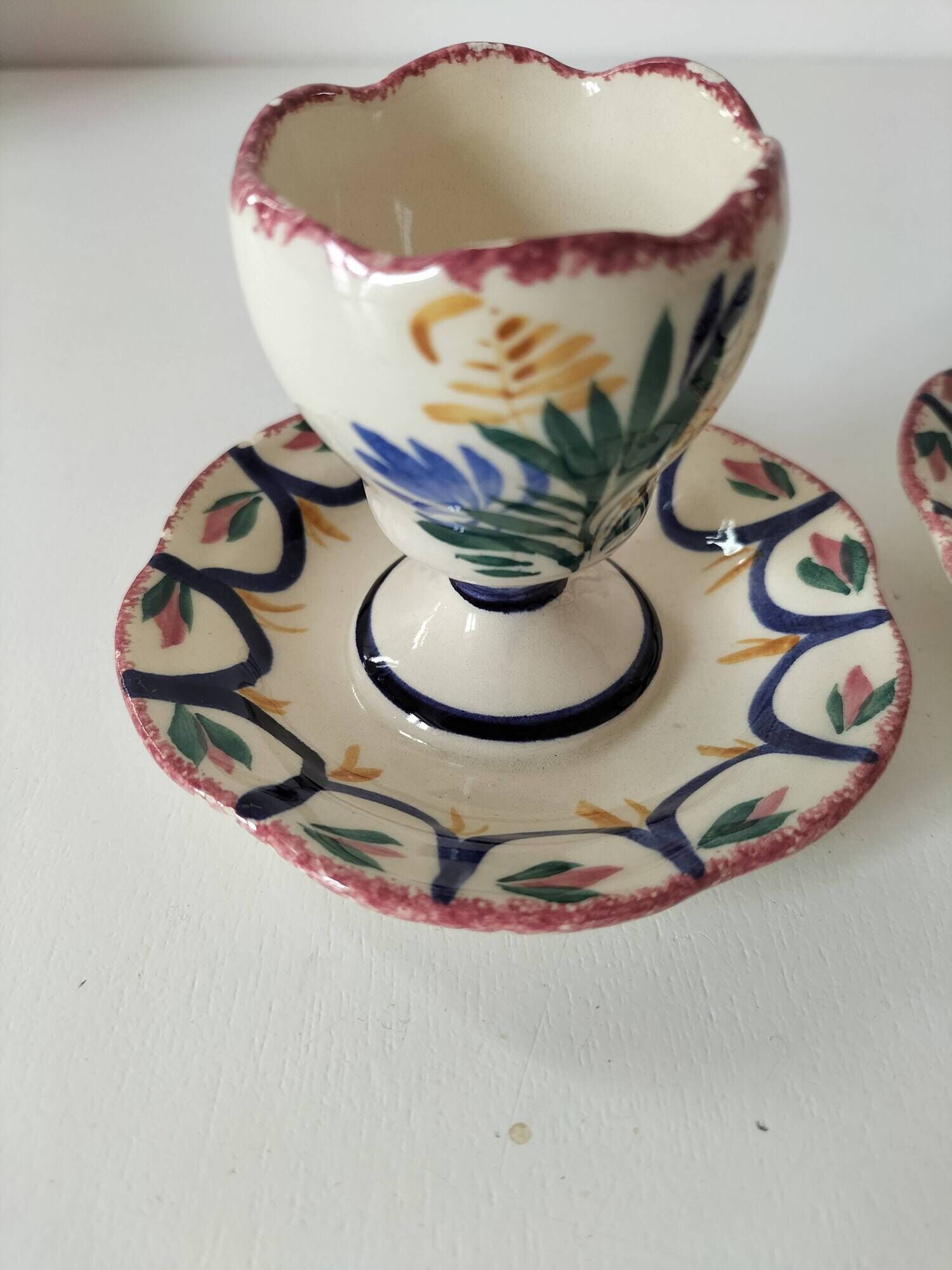 Pair of HB Quimper egg cups with integrated pedestal base, floral decoration