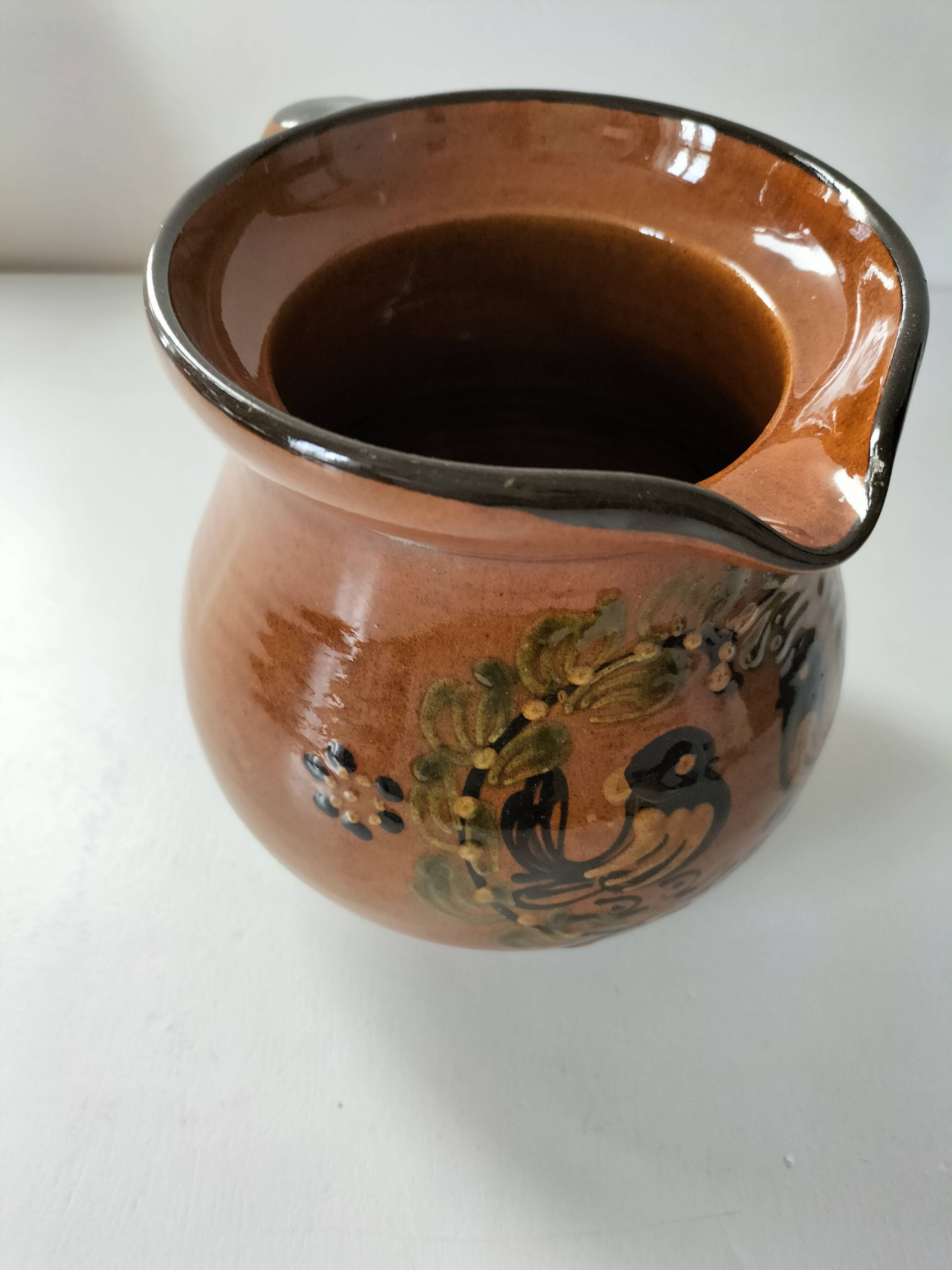 Glazed earthenware pitcher signed HR with a design of stylised birds.