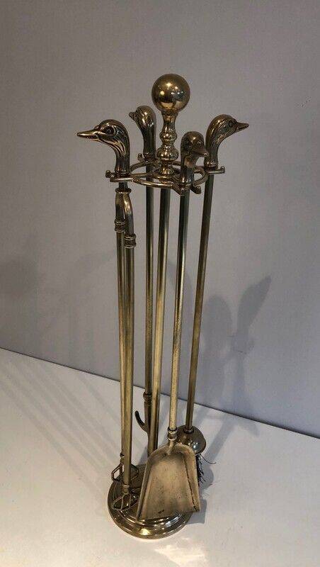 Neoclassical brass fire accessory with duck head decorations.