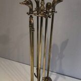 Neoclassical brass fire accessory with duck head decorations.