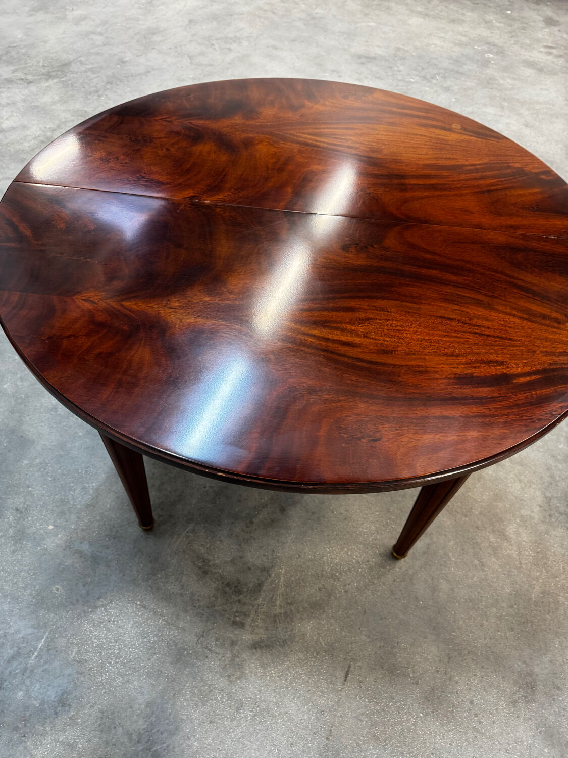 Extendable mahogany round table in Louis XVI style