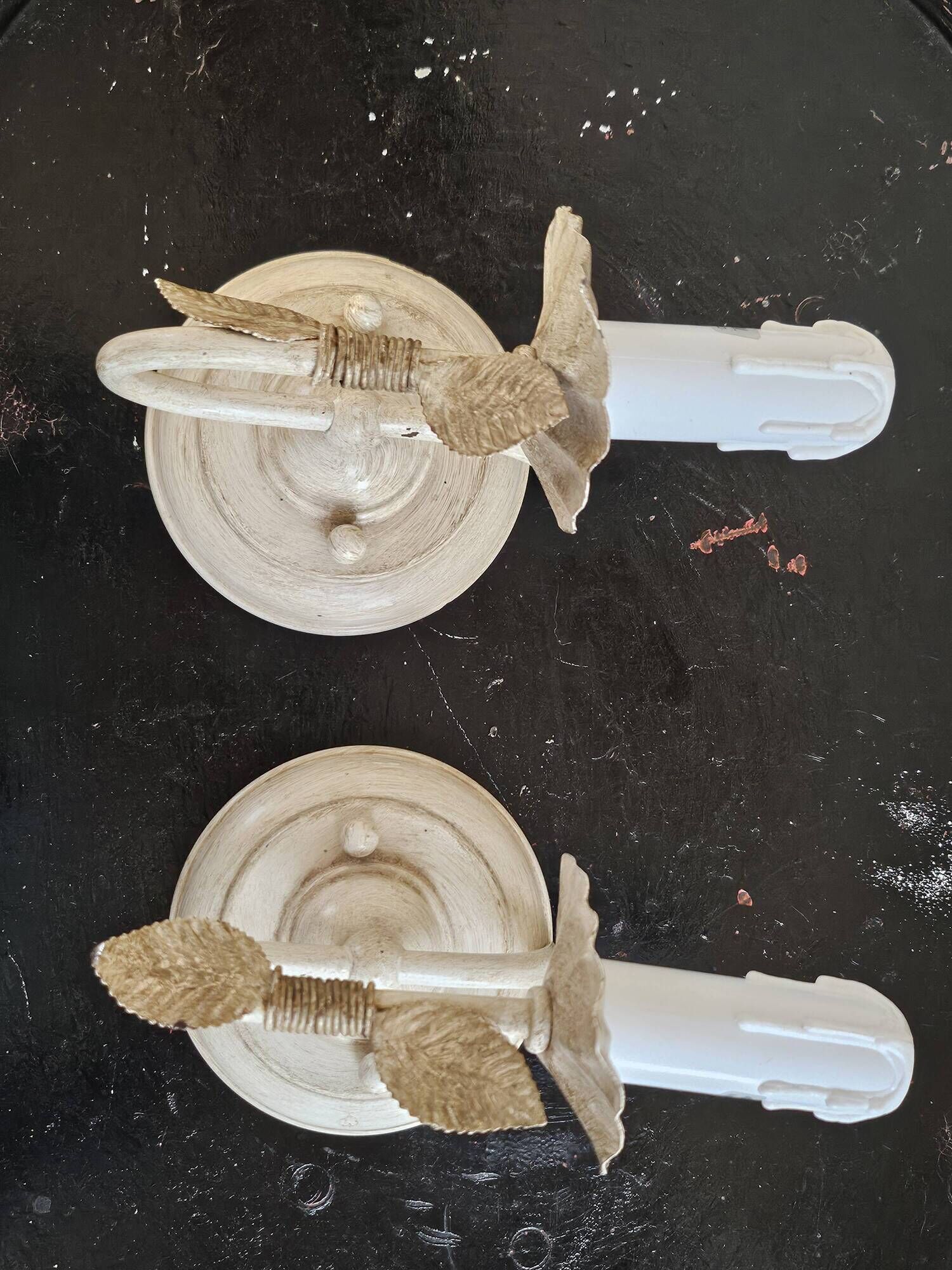 Pair of cream patinated metal wall sconces with floral decoration.