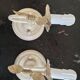 Pair of cream patinated metal wall sconces with floral decoration.