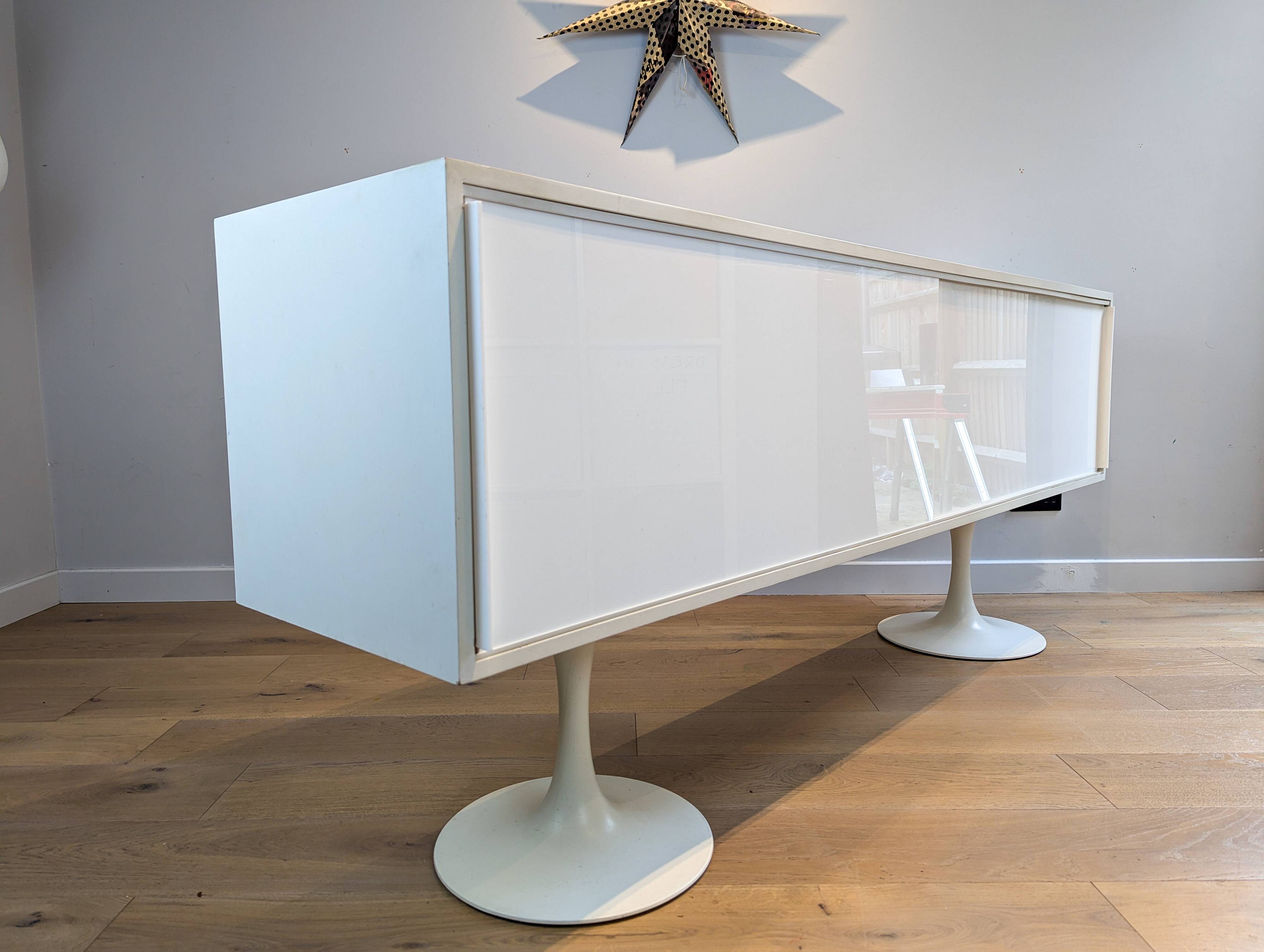 A vintage mid century space age sideboard with white sliding doors