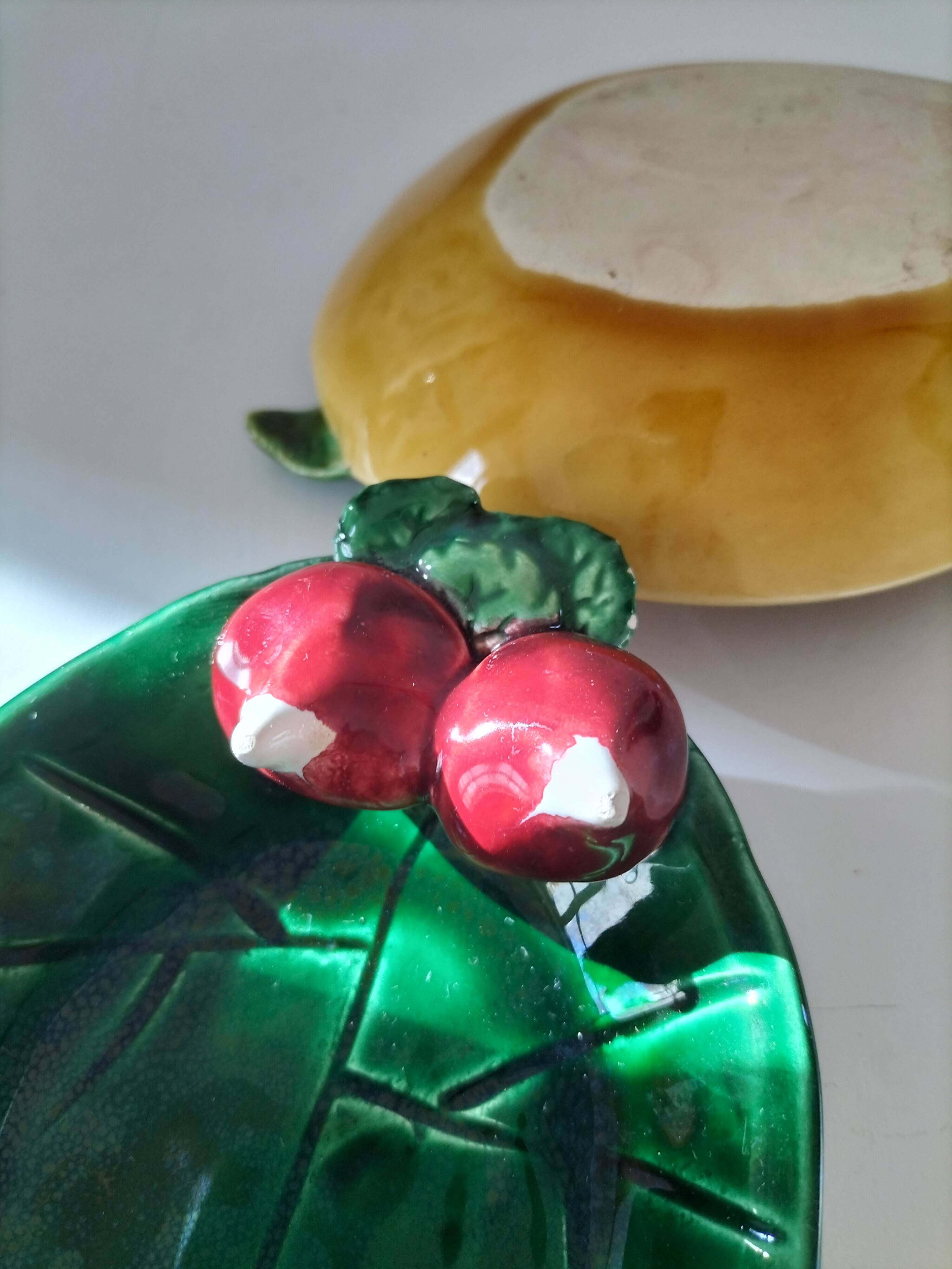 Two relief bowls with leaf designs, radishes, and tomatoes.
