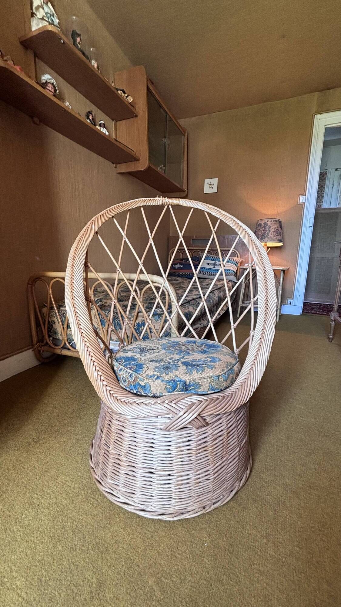 Vintage shell chair in woven rattan with original cushion.