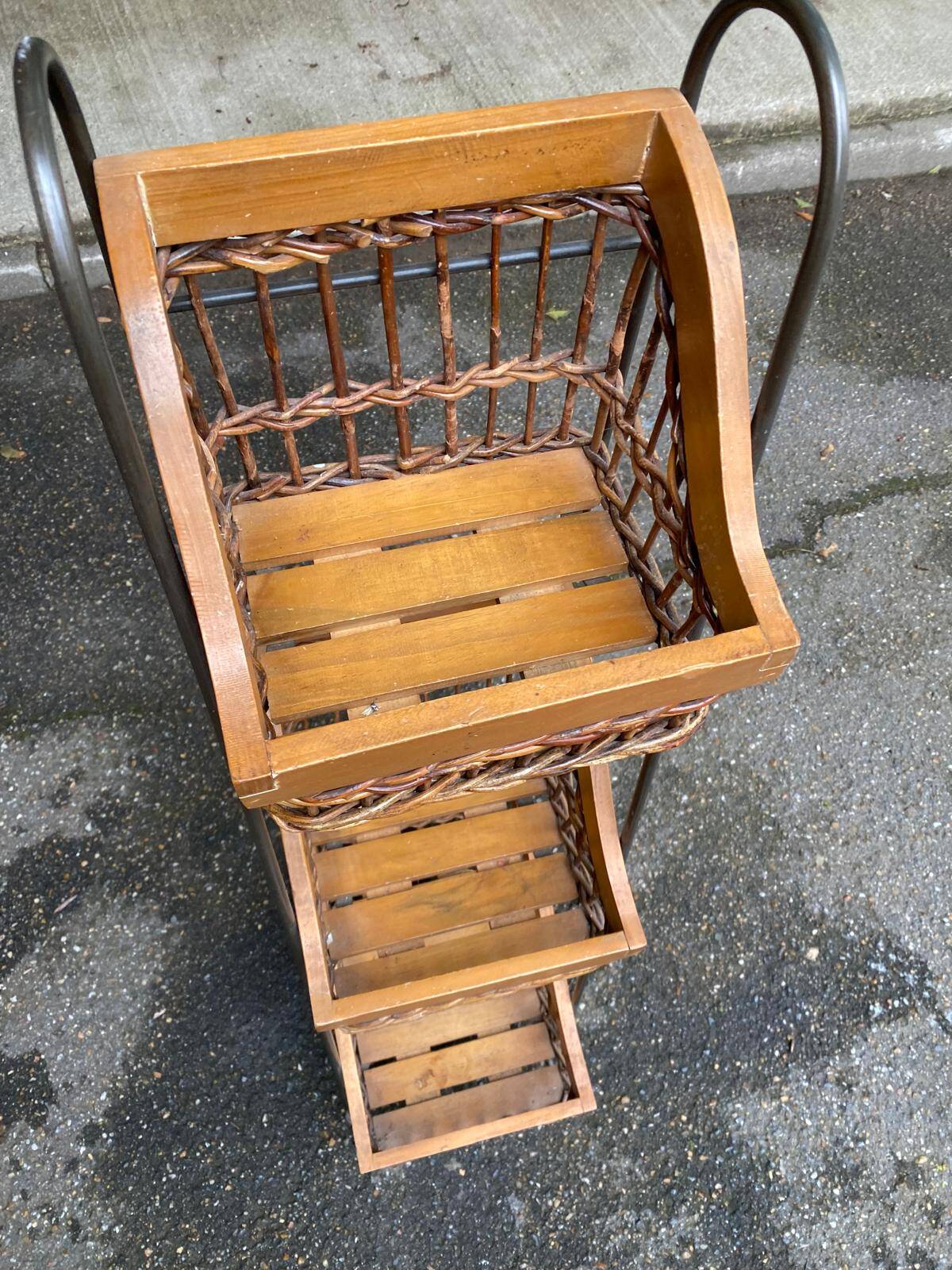 Woven rattan and steel display shelf in the shape of a staircase.