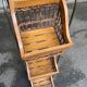 Woven rattan and steel display shelf in the shape of a staircase.