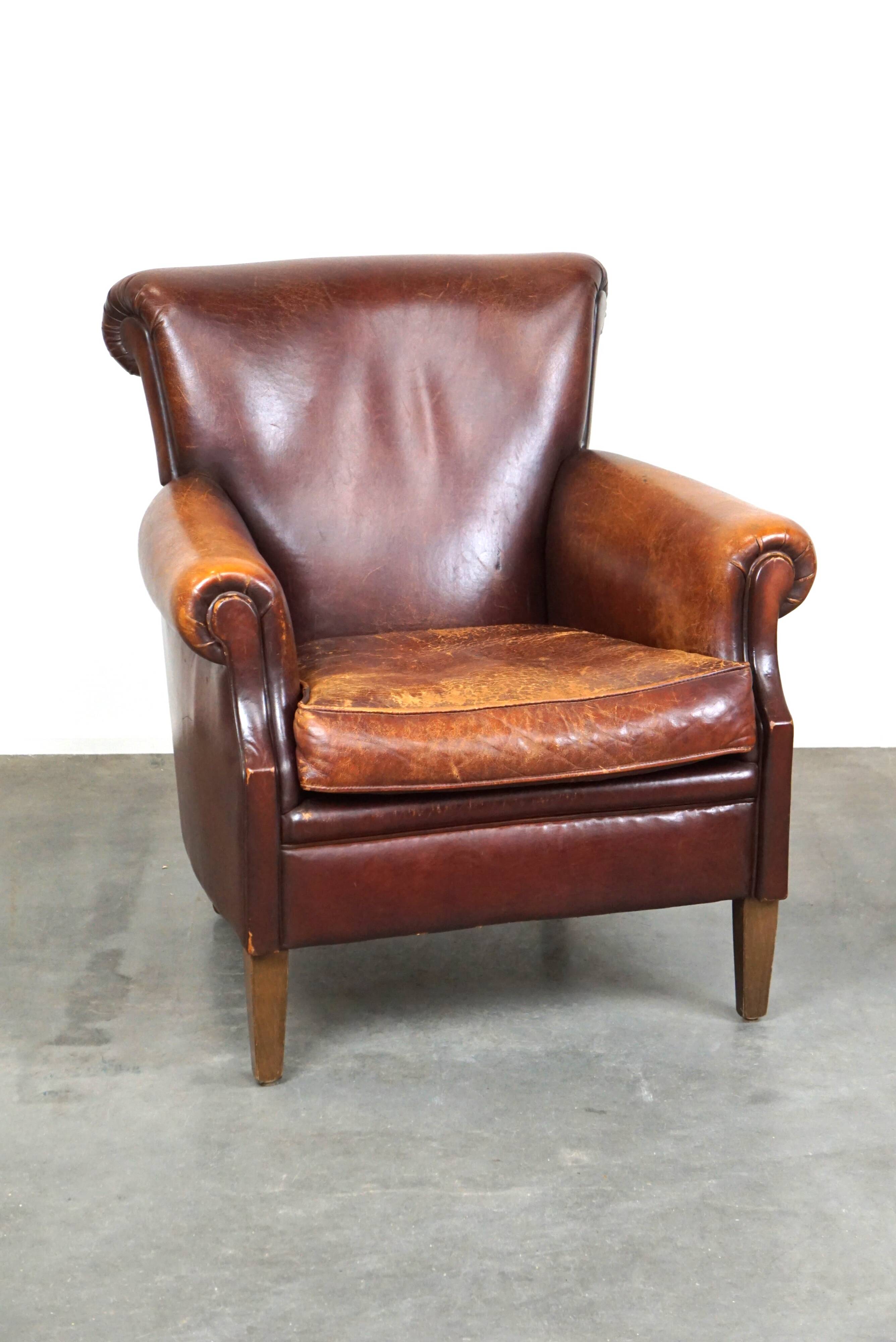 Fauteuil en cuir de mouton robuste et usé mais très confortable avec une belle patine