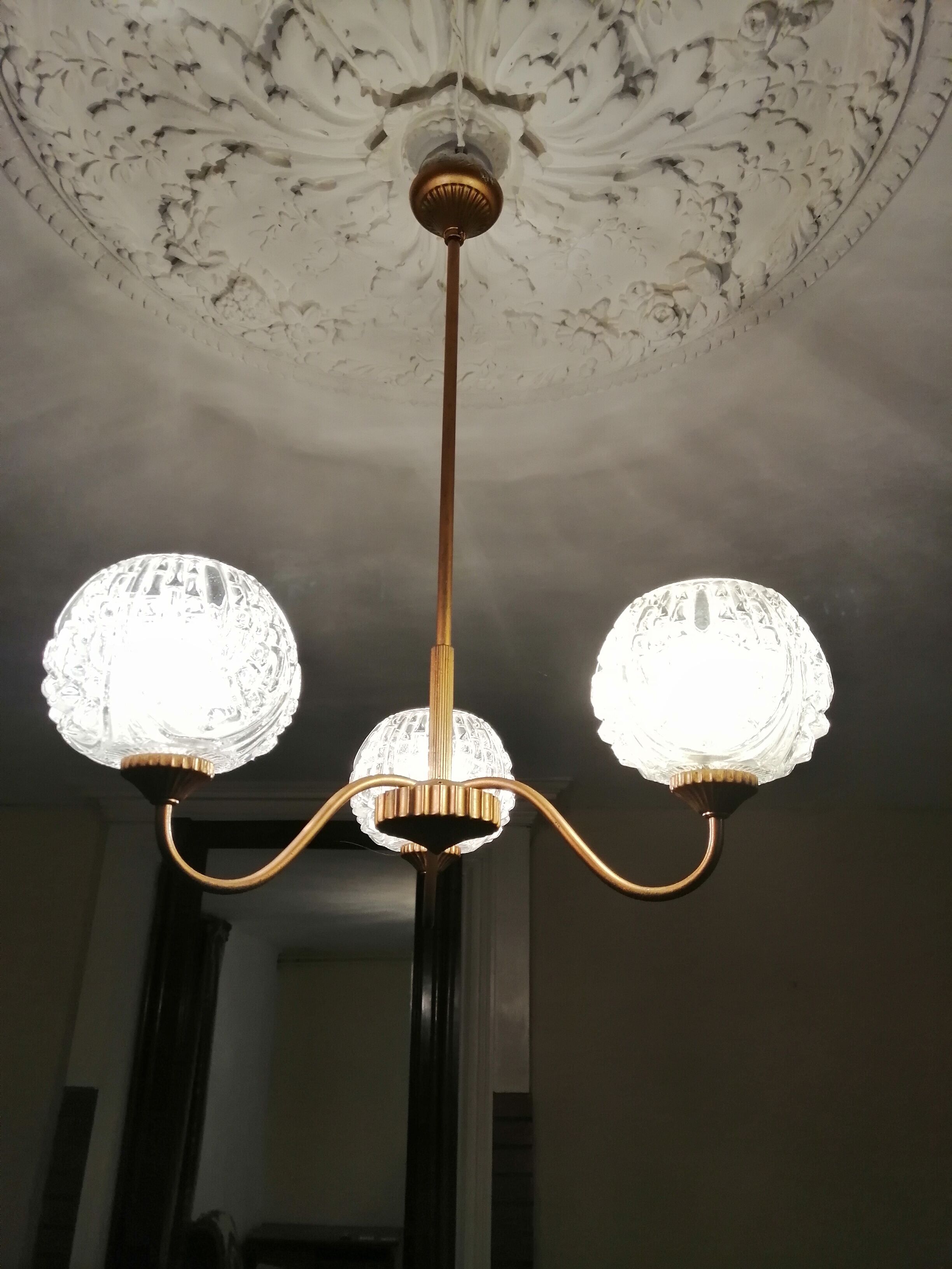 antique chandelier has 3 globes