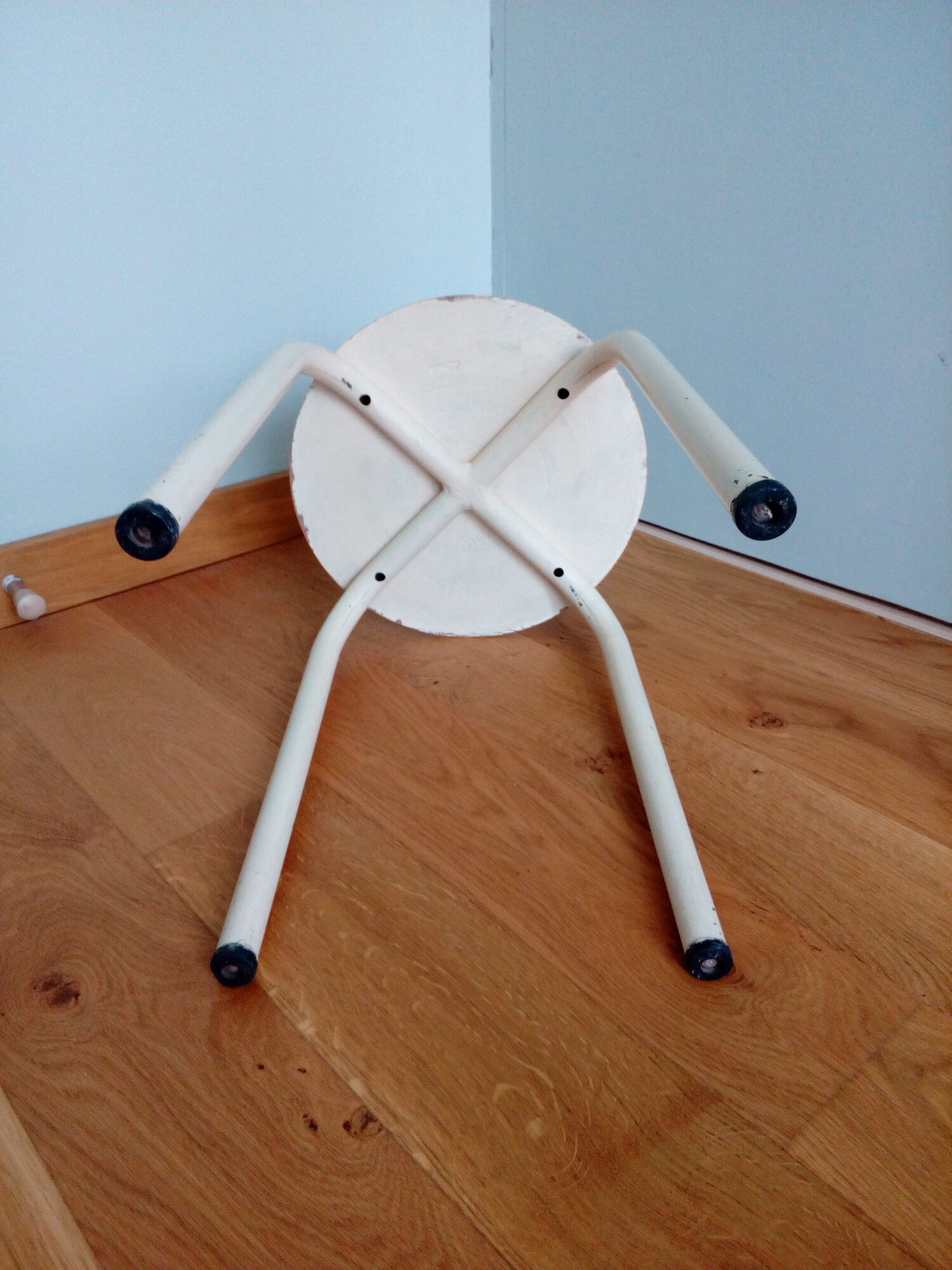 Industrial tubular metal stick sitting round in wood