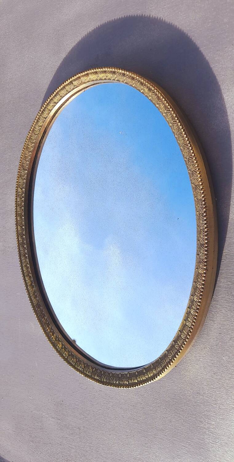 Oval mirror in gold metal