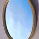 Oval mirror in gold metal