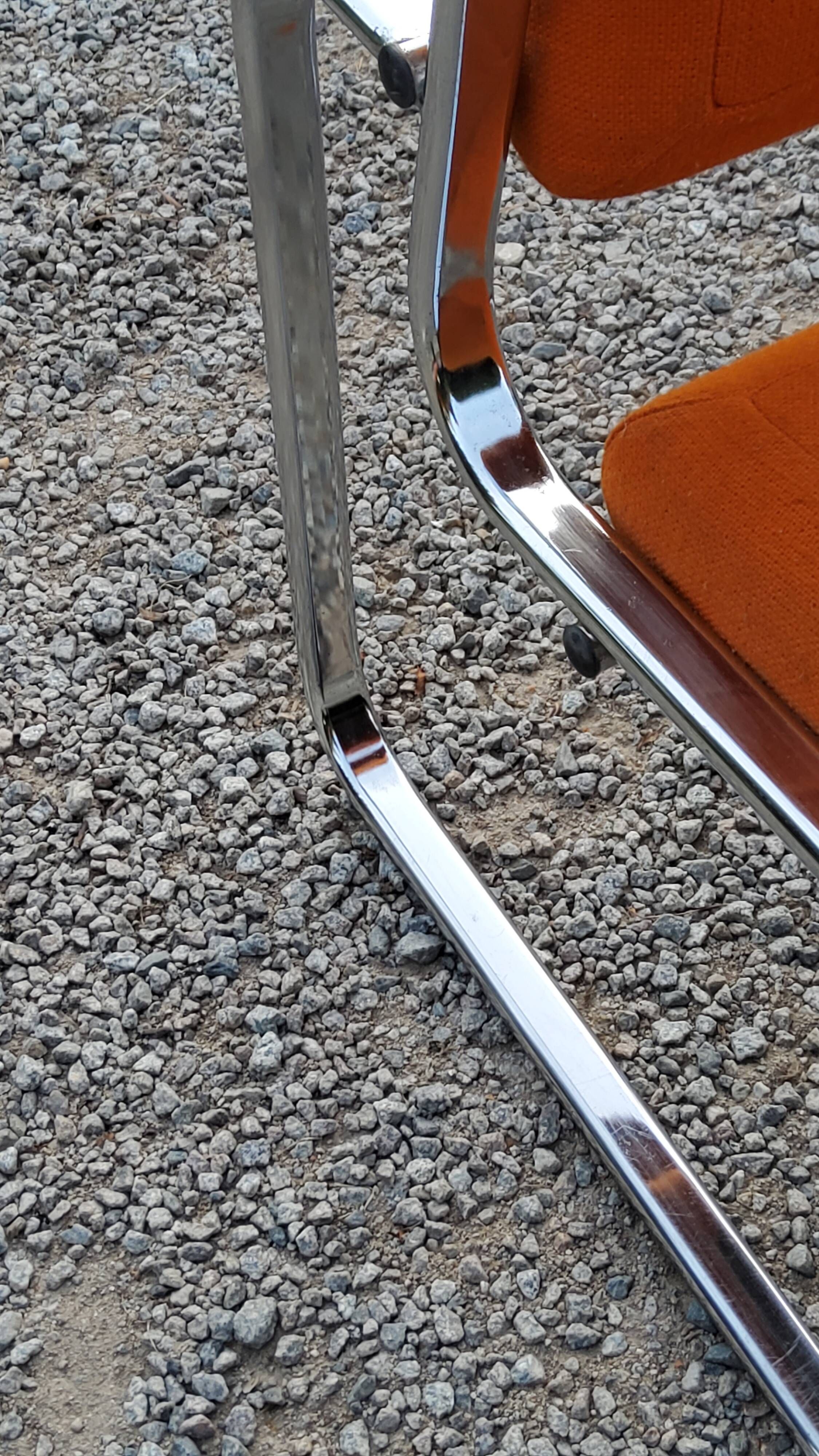 Pair of designer armchairs in orange fabrics and chrome tubes from the 70s