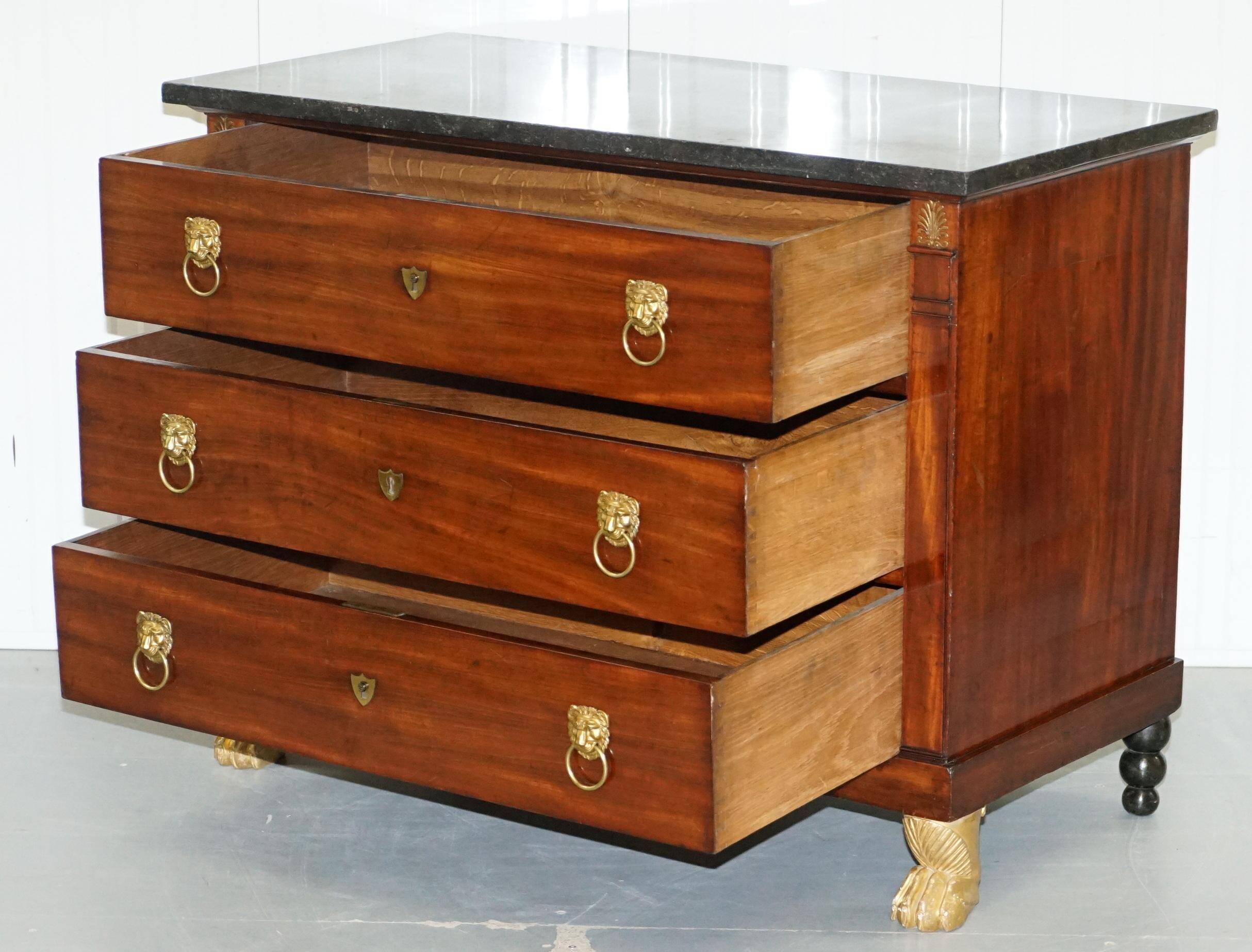 19th-century Empire commode with a marble top and lion paw feet.