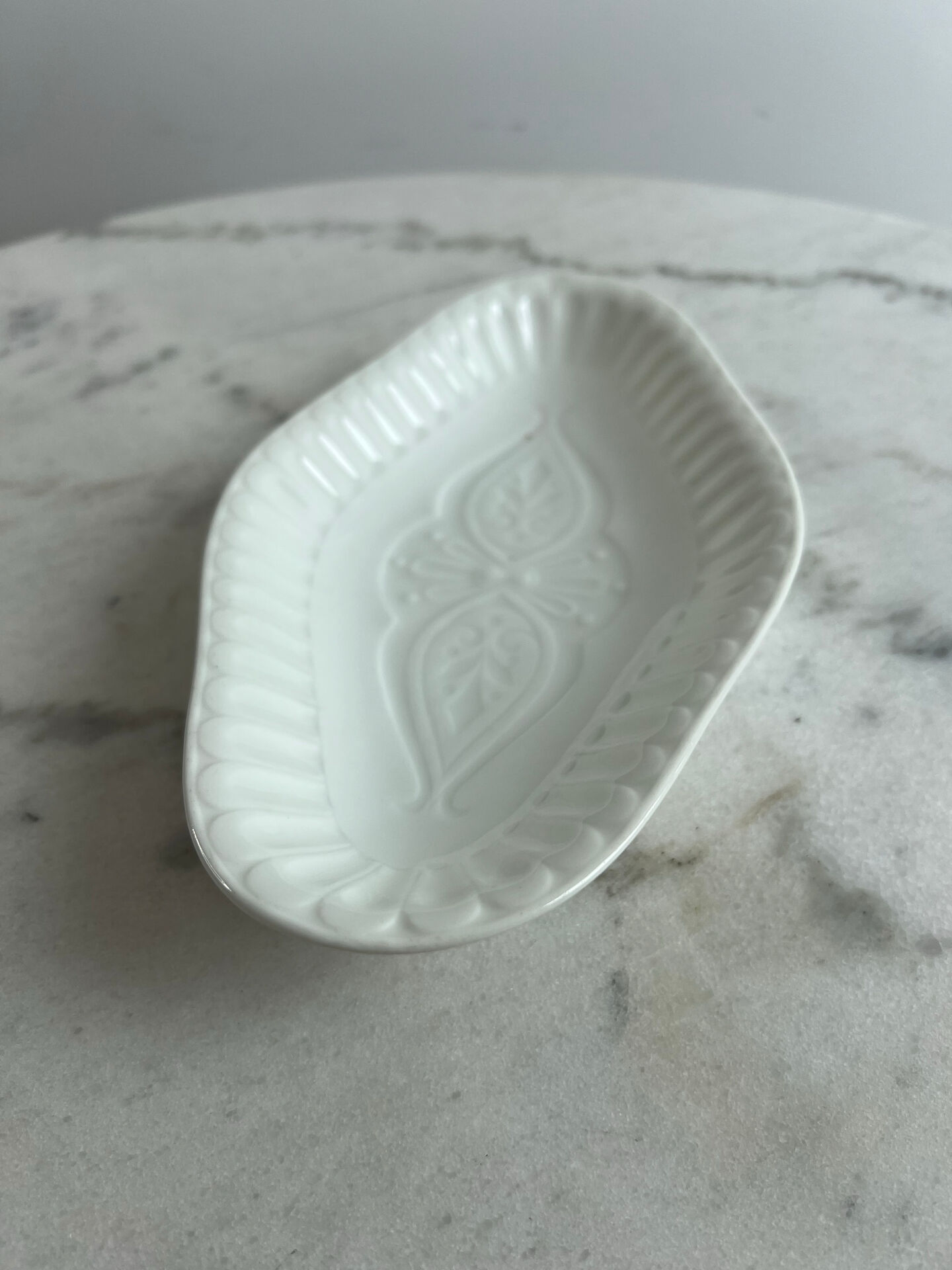Oval white porcelain ramekin — raised floral pattern