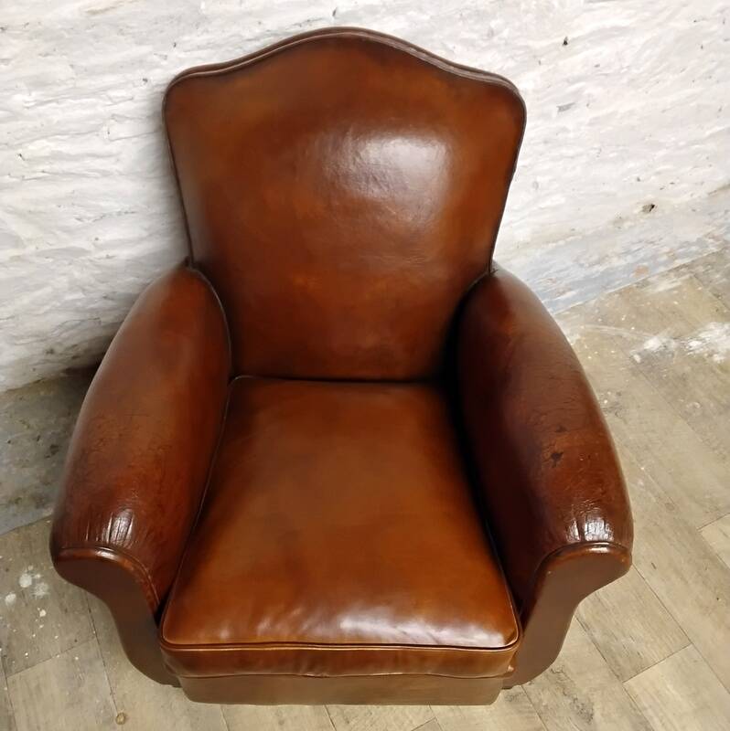 Antique club chair with gendarme hat back