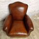 Antique club chair with gendarme hat back