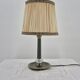 Brass table lamp with green patina and empire-style fabric shade.