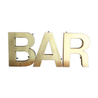 Old brass sign letters, word BAR