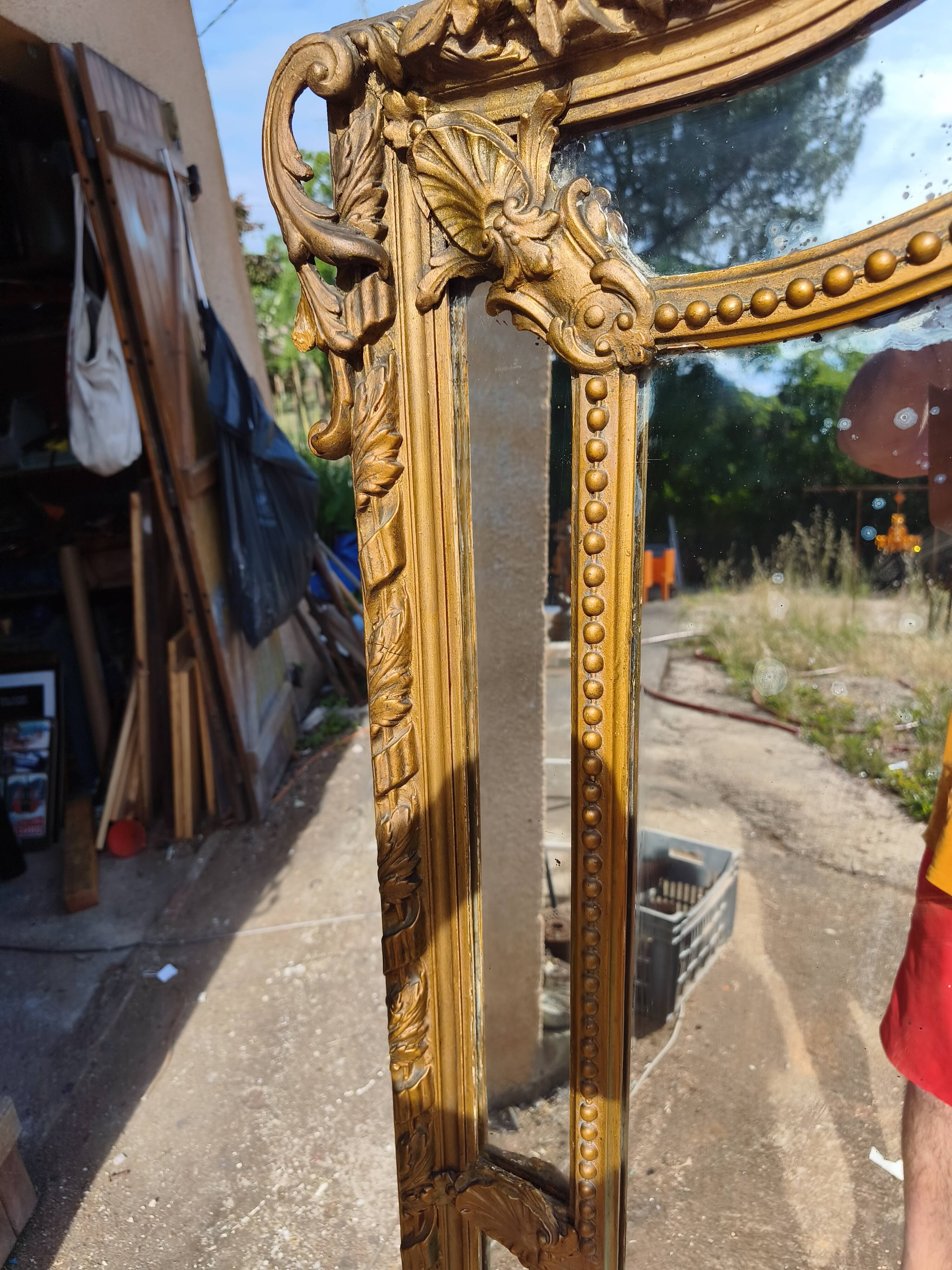 Large closed mirror, 19th century, wood and gilded stucco.