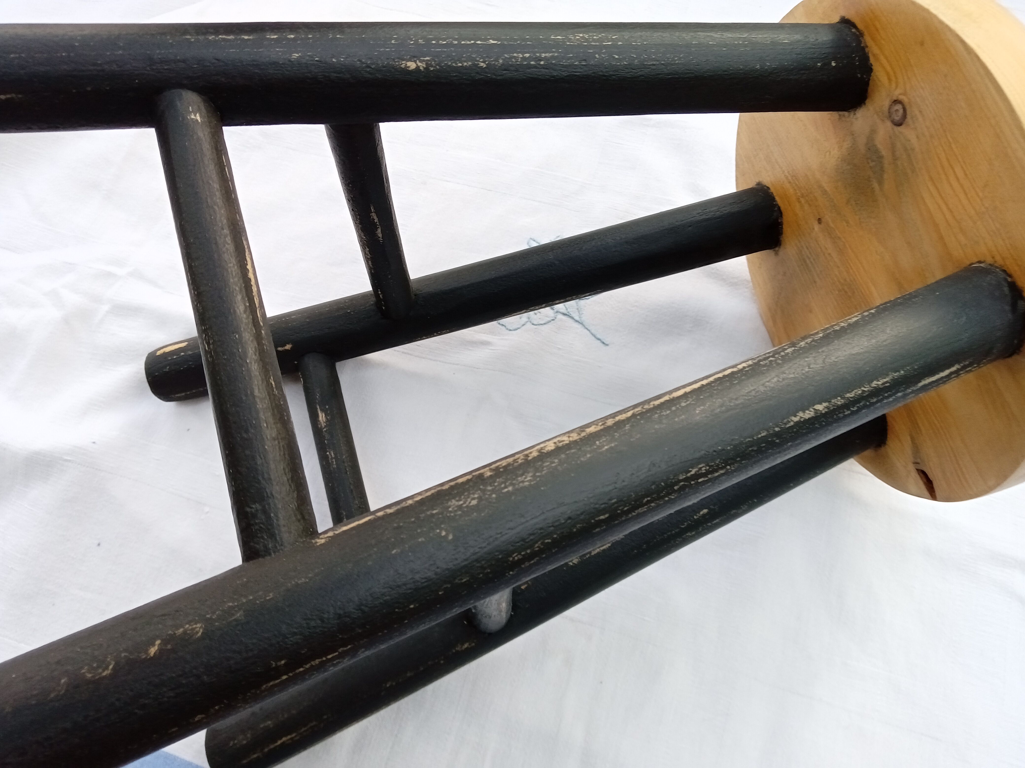 Low wooden stool and black patina