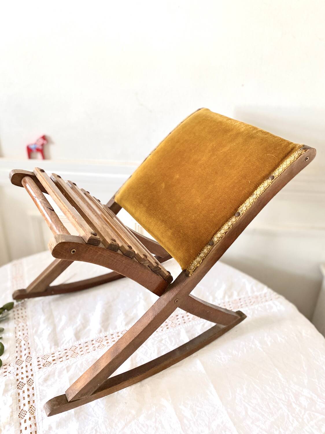Old wooden rocking footrest with velvet fabric