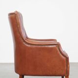 Cowhide armchair in good condition, finished with decorative nails