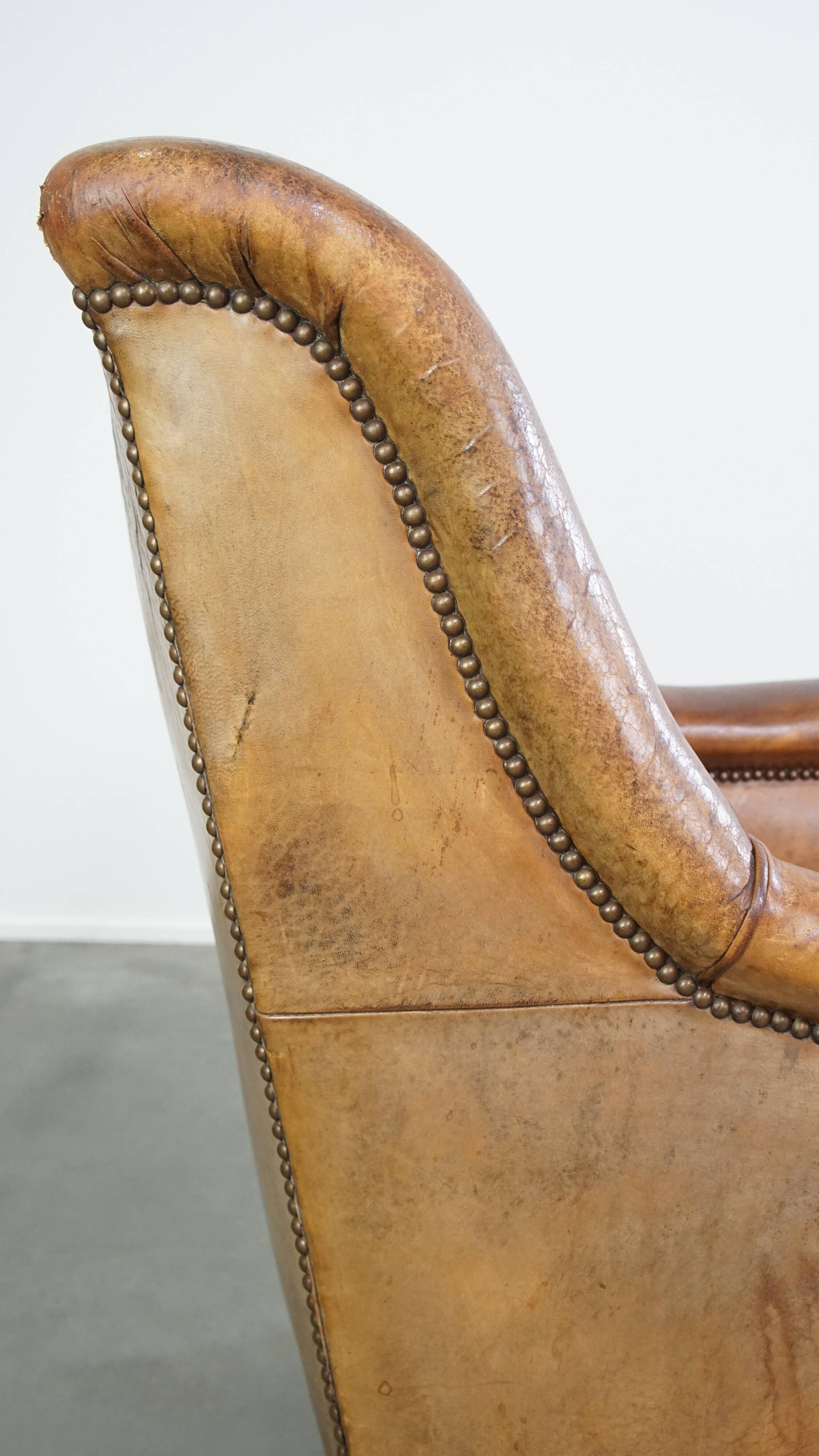 Fauteuil en cuir de mouton antique caractéristique avec de beaux détails et un design unique