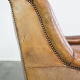 Characteristic antique sheepskin leather armchair with beautiful details and a unique design