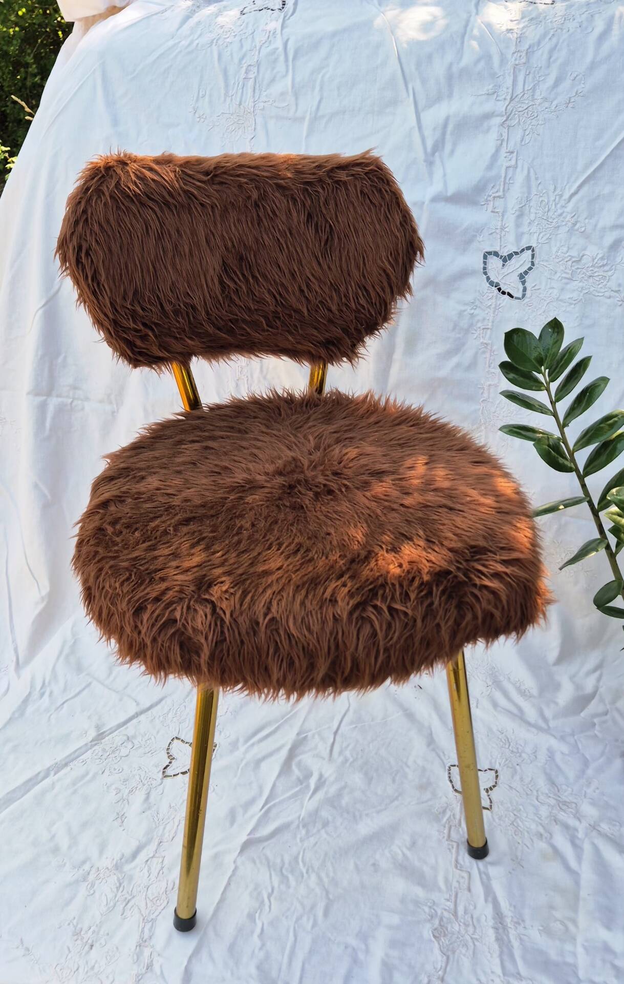 Vintage shaggy chair in faux fur with golden metal legs.