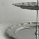 Three-tiered serving trolley in shiny stainless steel.